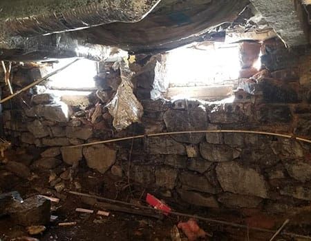 Deteriorated historic stone foundation with mortar decay before repair