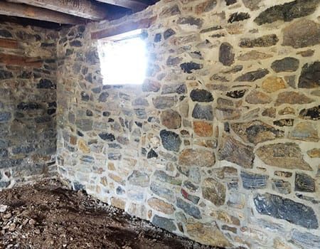 Same historic stone wall rebuilt stone by stone after restoration