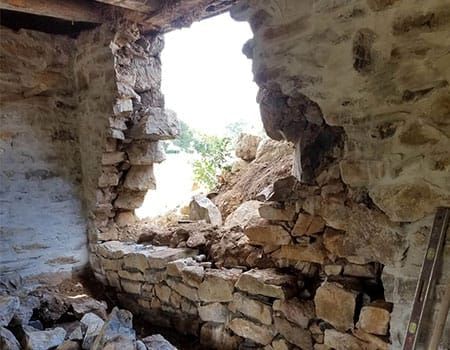 Historic stone wall with a collapsed section before rebuilding