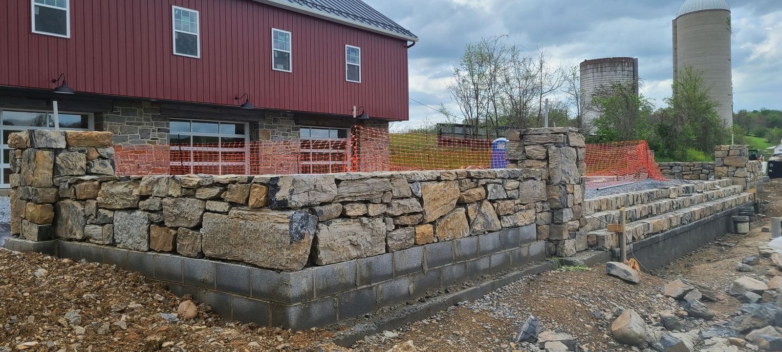 Long historic stone retaining wall rebuilt by Poor Boys' Enterprises