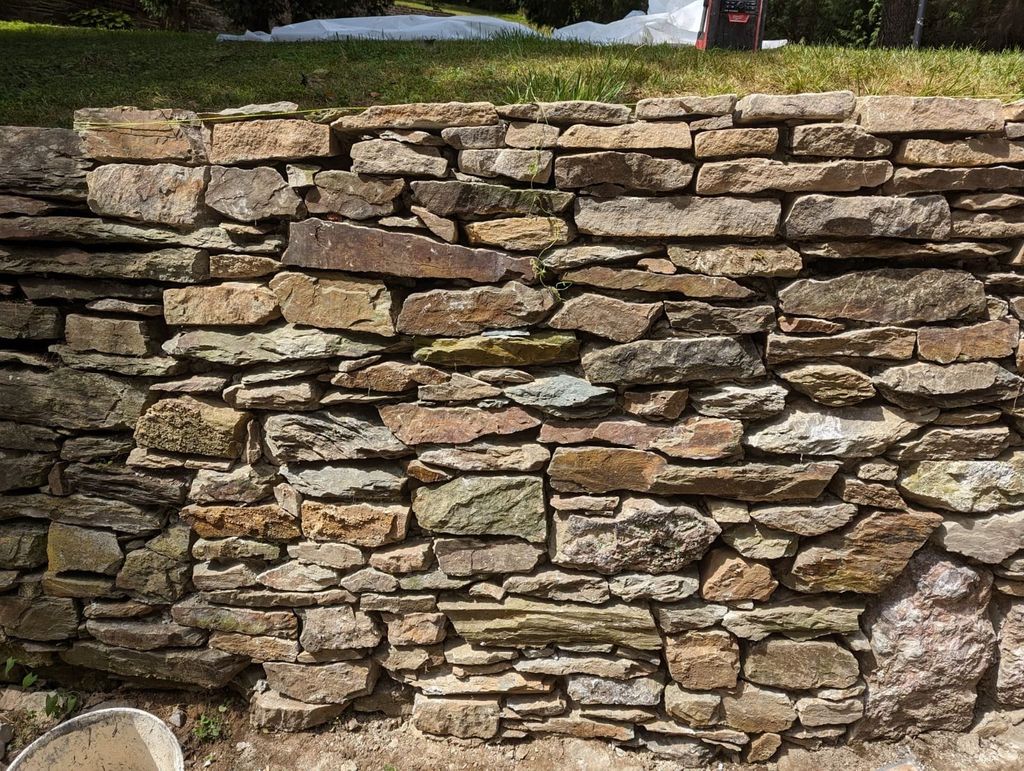Hand-laid dry stone retaining wall restored by Poor Boys' Enterprises